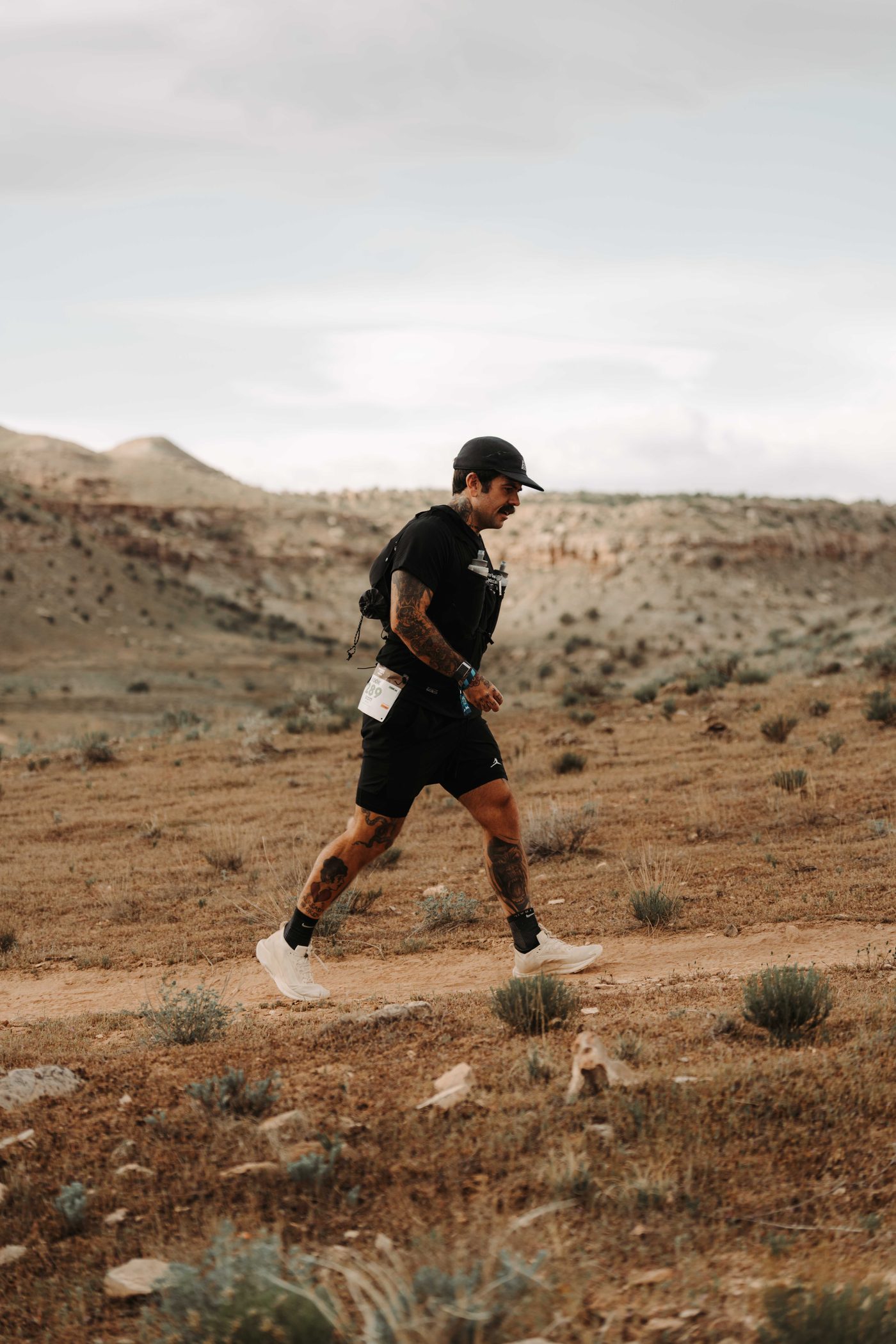 Scott Britton running a desert trail with a hydration vest
