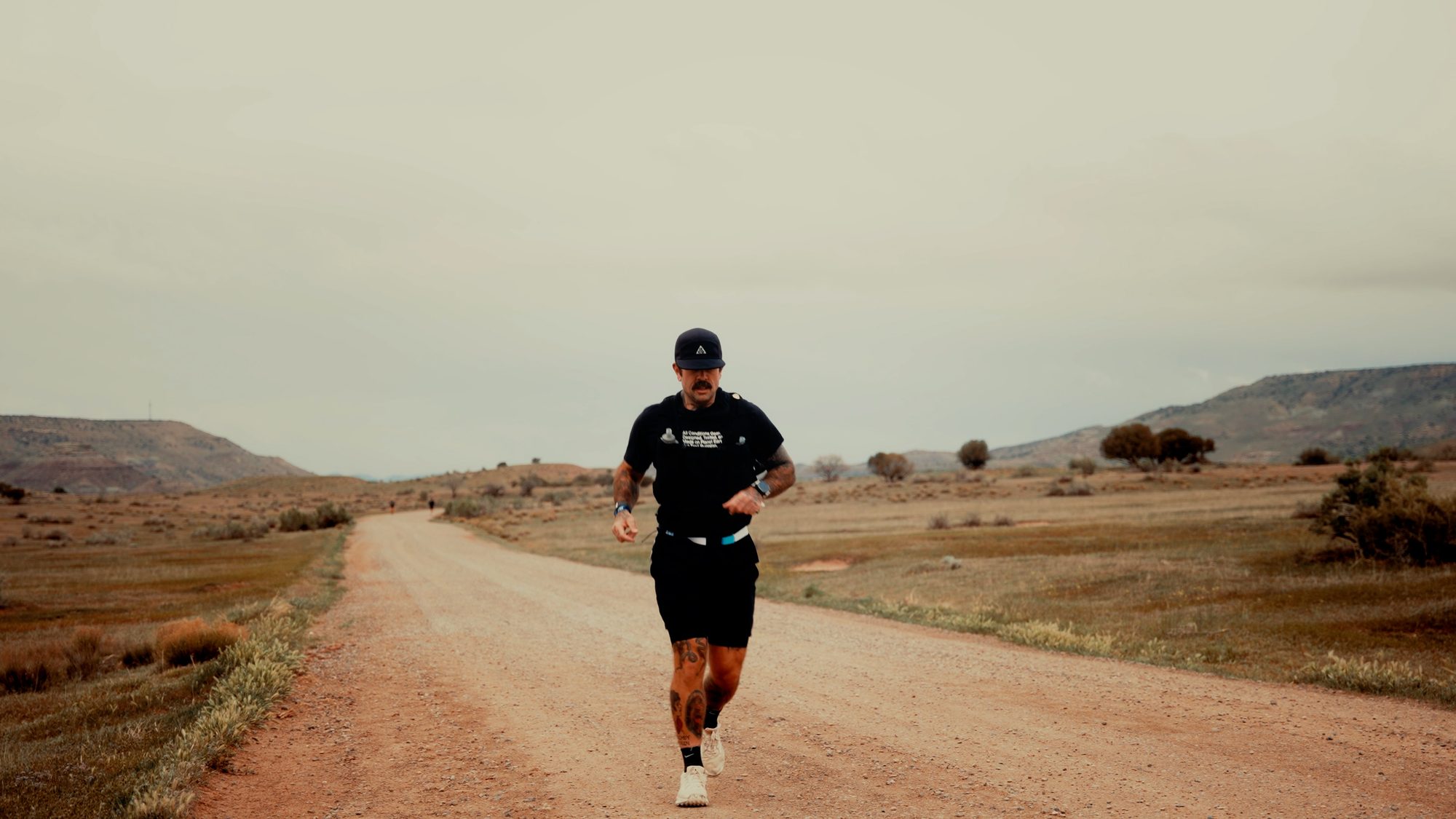 Lone runner on a long desert road